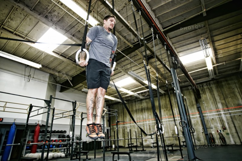 Caucasian man on rings in gym