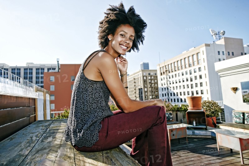 Mixed race woman sitting on urban rooftop