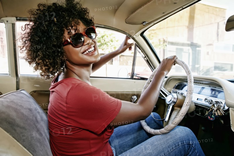Mixed race woman driving vintage car