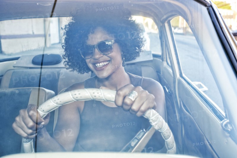 Mixed race woman driving vintage car