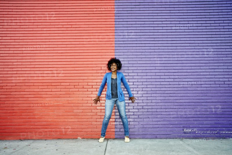 Mixed race woman standing by colorful wall