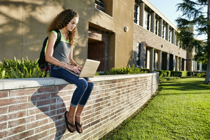 Mixed race student using laptop