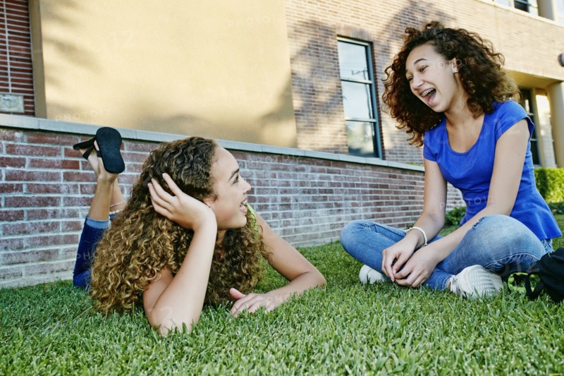 Mixed race girls talking in grass
