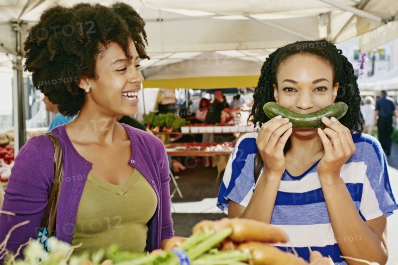 Women smiling together at outdoor market