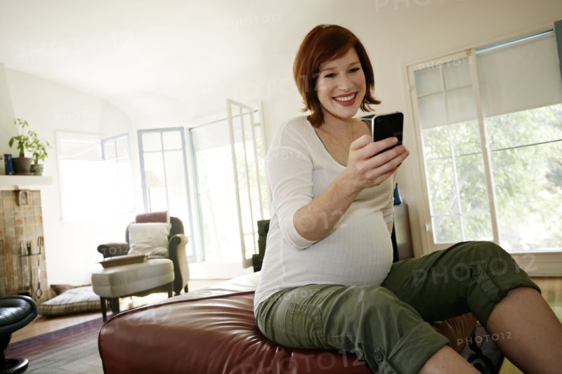 Pregnant Caucasian woman using cell phone