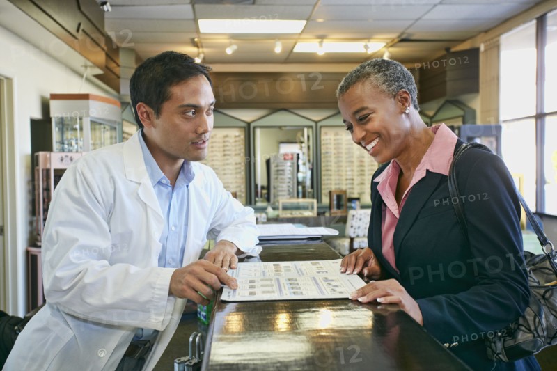 Optometrist talking to patient in office