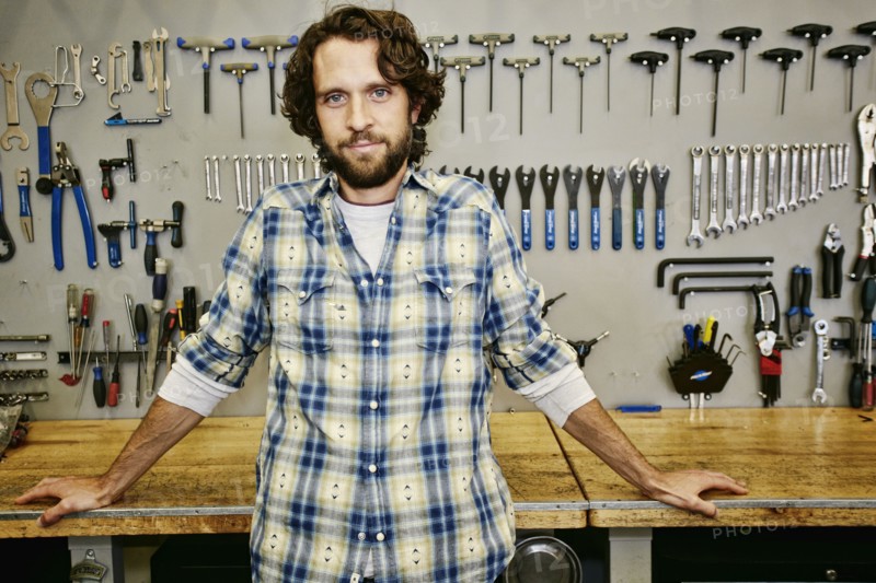 Caucasian man smiling in bicycle repair shop