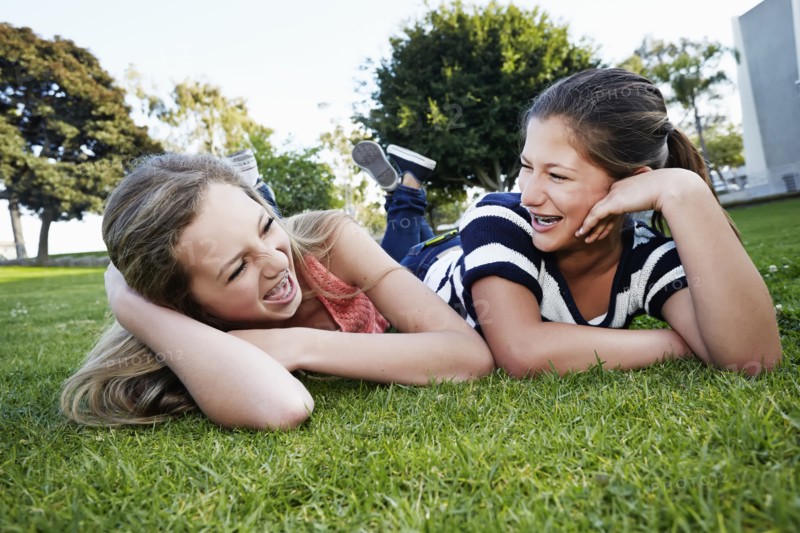 Teenage girls laying in grass