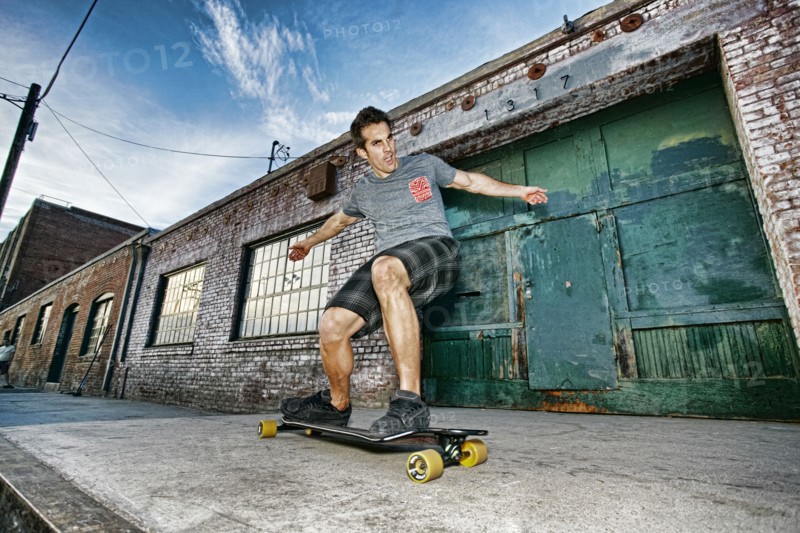 Caucasian man riding skateboard on city street