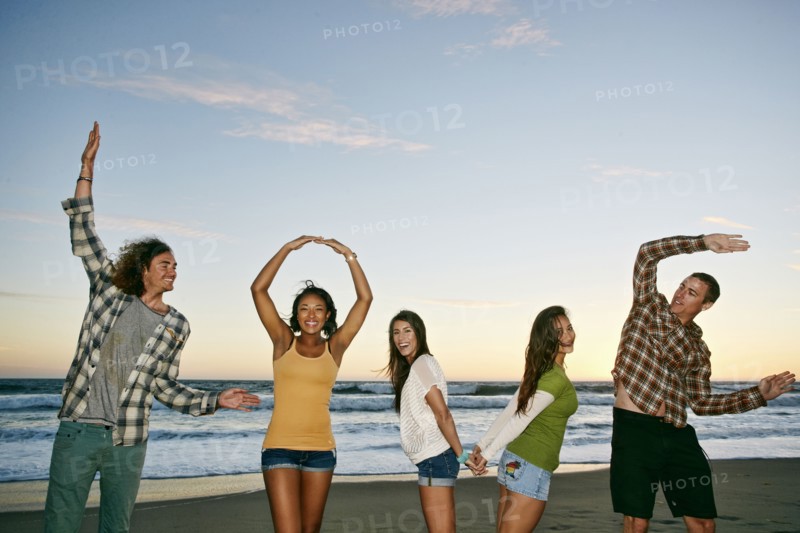 Friends spelling Love on beach