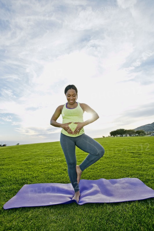 Pregnant woman practicing yoga in park