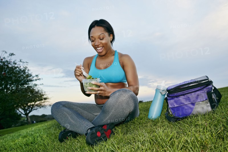 Pregnant woman eating salad in park
