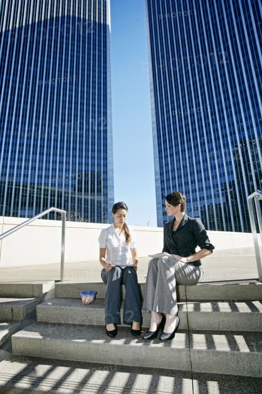 Businesswomen talking on city staircase