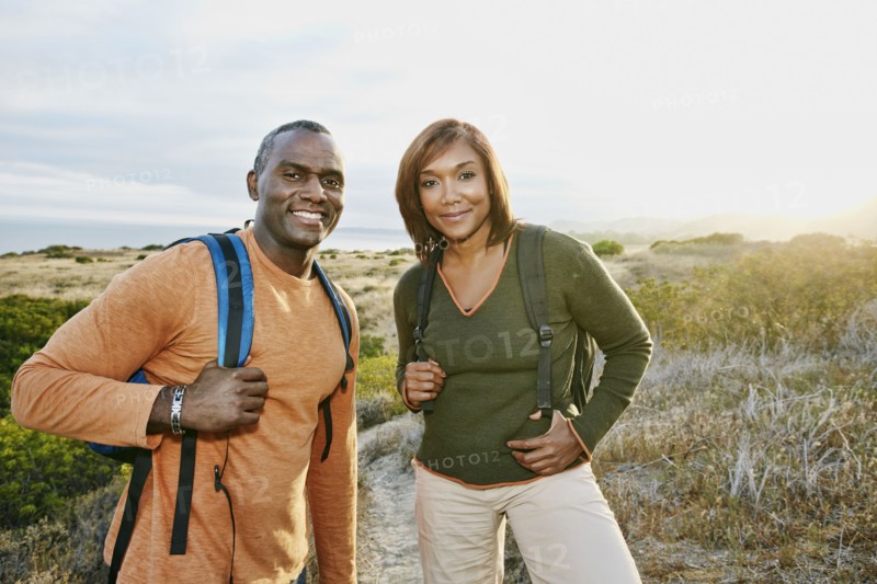 Black couple smiling on rural hillside