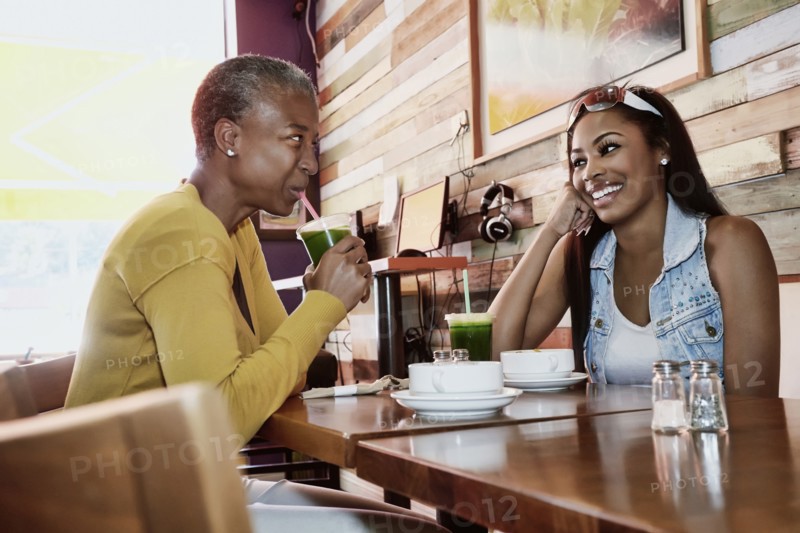 Mother and daughter drinking juice in cafe