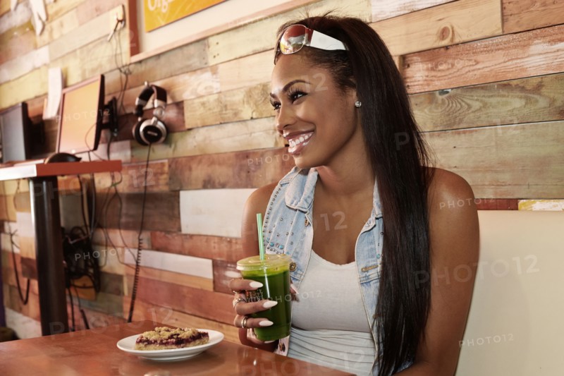 African American woman having juice in cafe