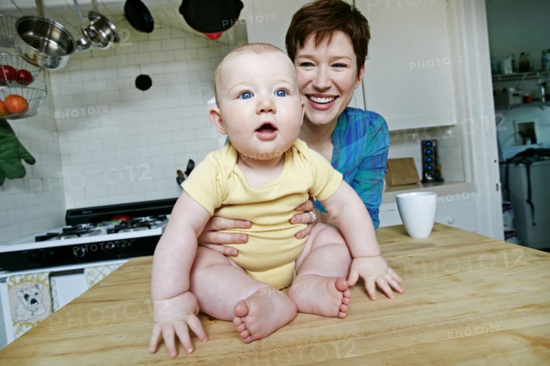 Caucasian mother and baby relaxing in kitchen
