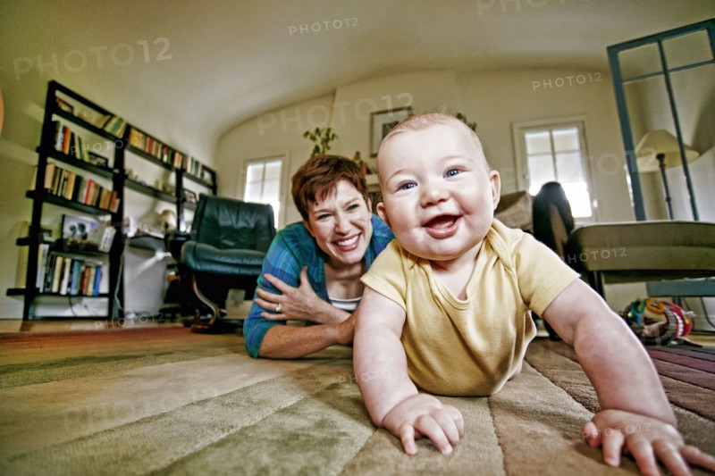 Caucasian mother and baby playing on living room floor