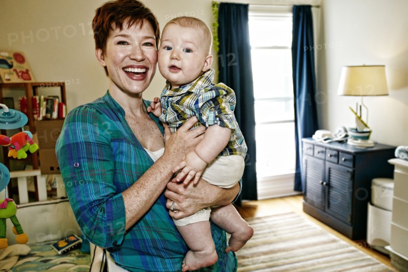 Caucasian mother holding baby in bedroom