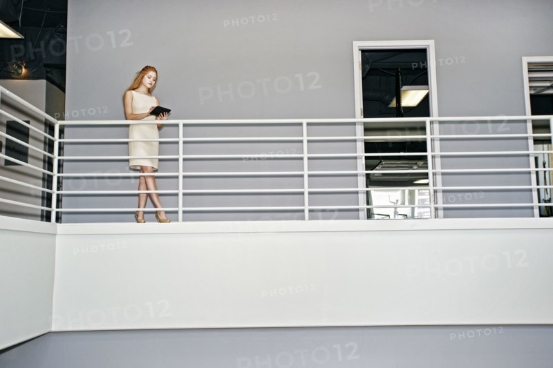 Caucasian businesswoman using digital tablet railing