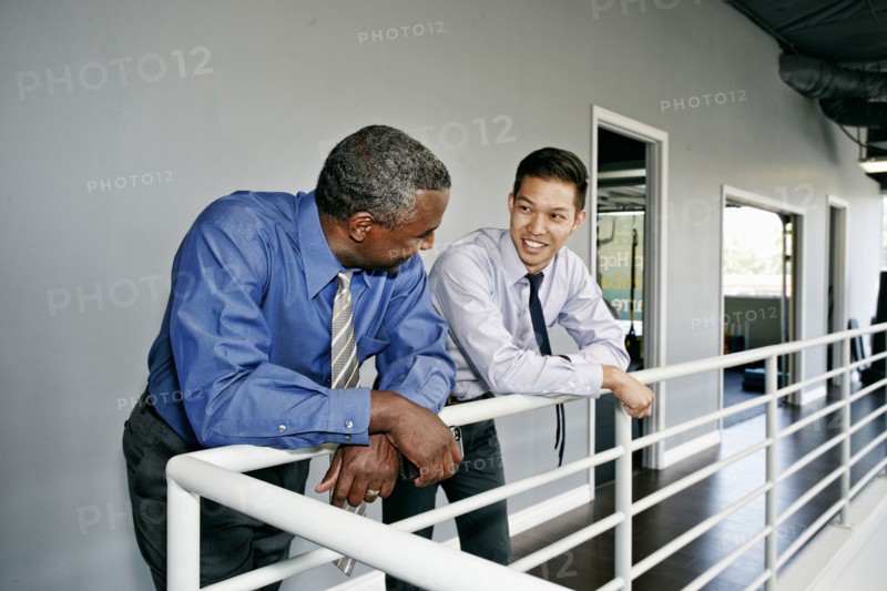 Businessmen talking at railing