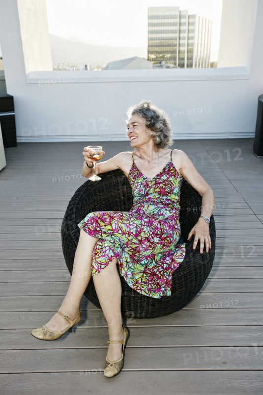 Caucasian woman drinking wine on urban rooftop