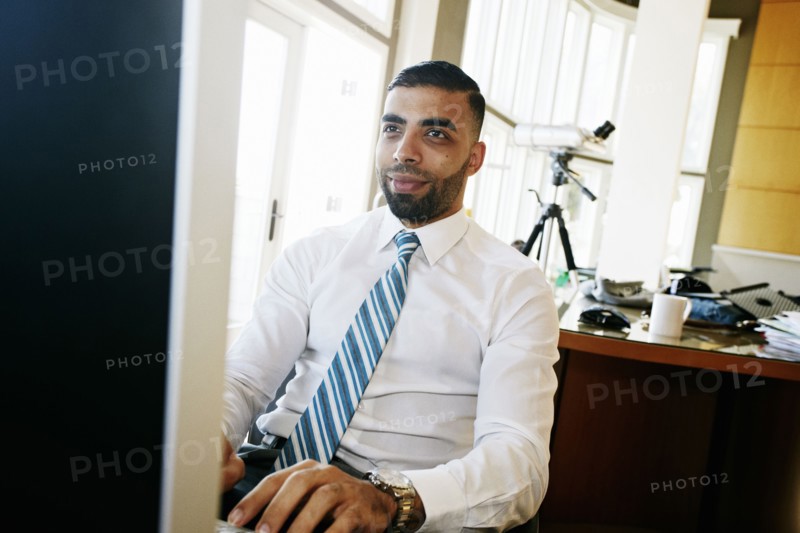 Middle Eastern businessman working at computer in office