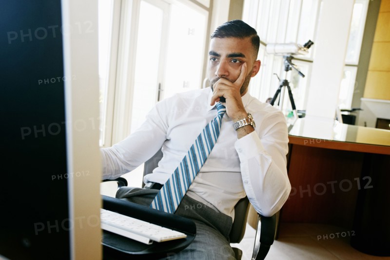 Middle Eastern businessman working at computer in office