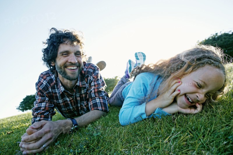 Father and daughter playing in grassy field