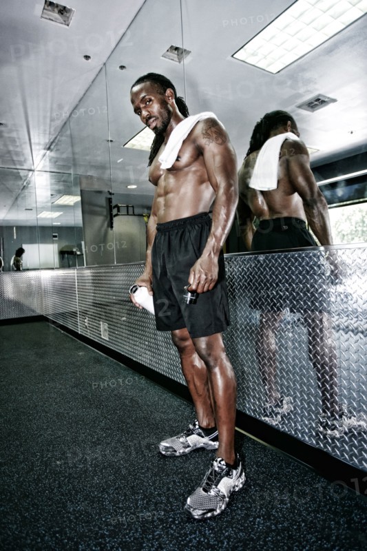 African American man standing at mirror in gym
