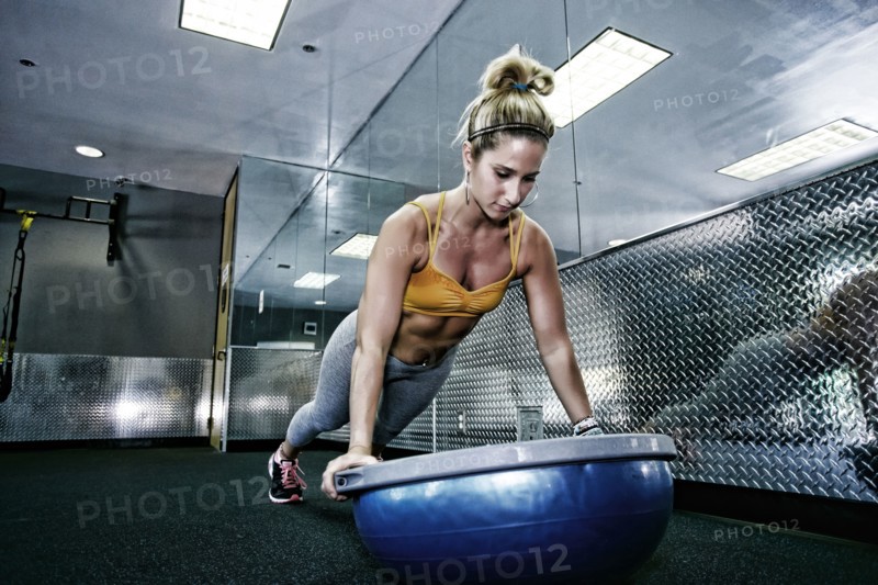 Caucasian woman doing push ups in gym