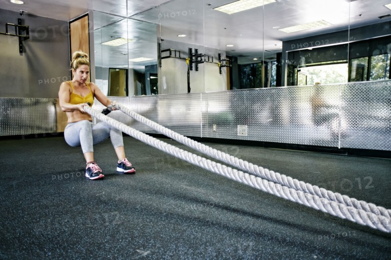 Caucasian woman working out with ropes in gym
