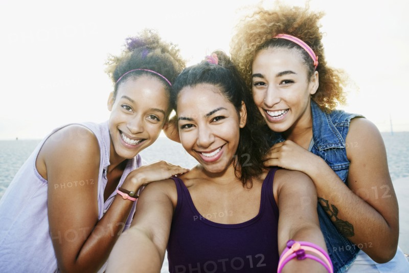 Smiling friends taking selfie at beach