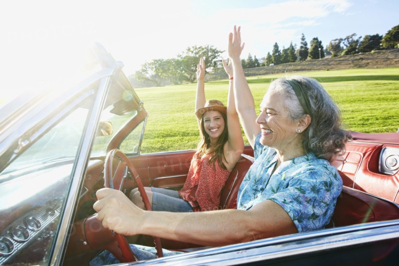 Mother and daughter driving in classic convertible