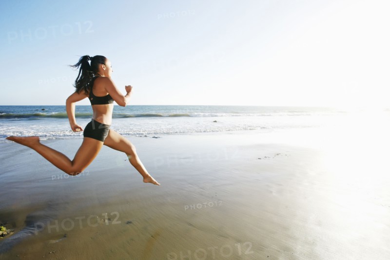 Mixed race woman running on beach