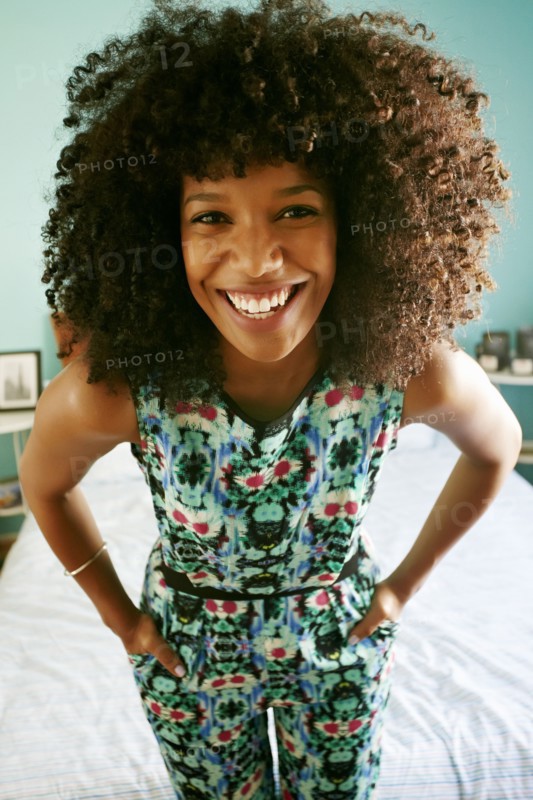 Close up of mixed race woman smiling in bedroom