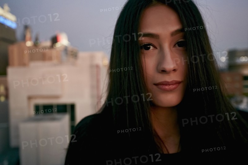 Serious mixed race woman on urban rooftop