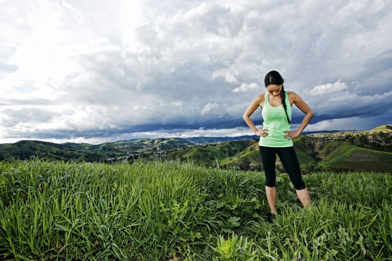 Mixed race athlete standing on rural hilltop