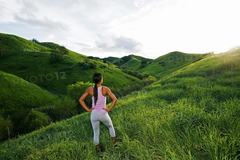 Black athlete admiring scenic view from rural hillside