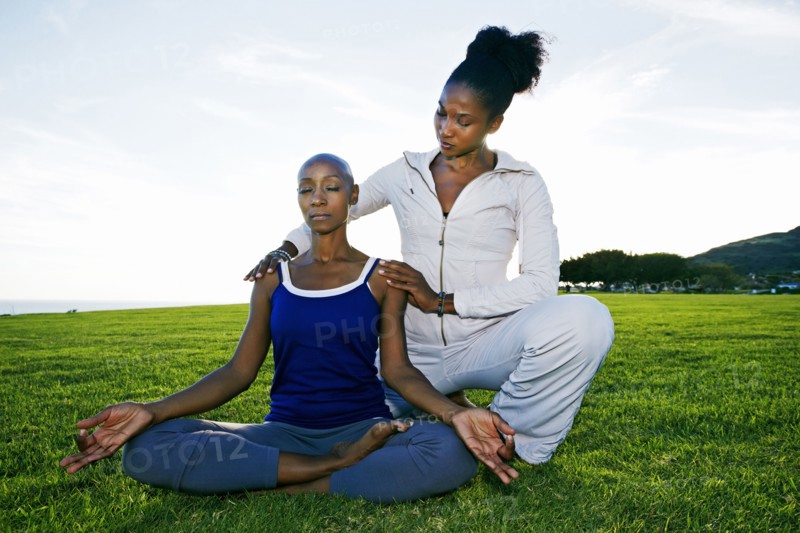 Woman practicing yoga with teacher in park