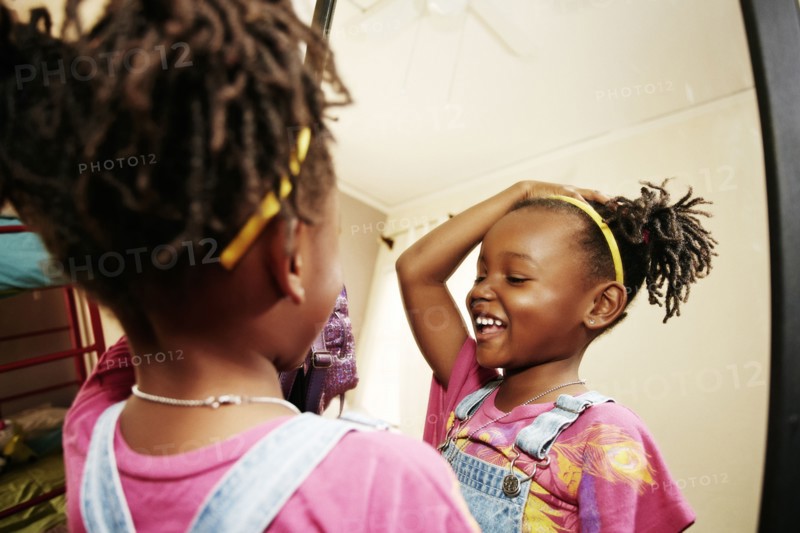 Black girl admiring herself in mirror