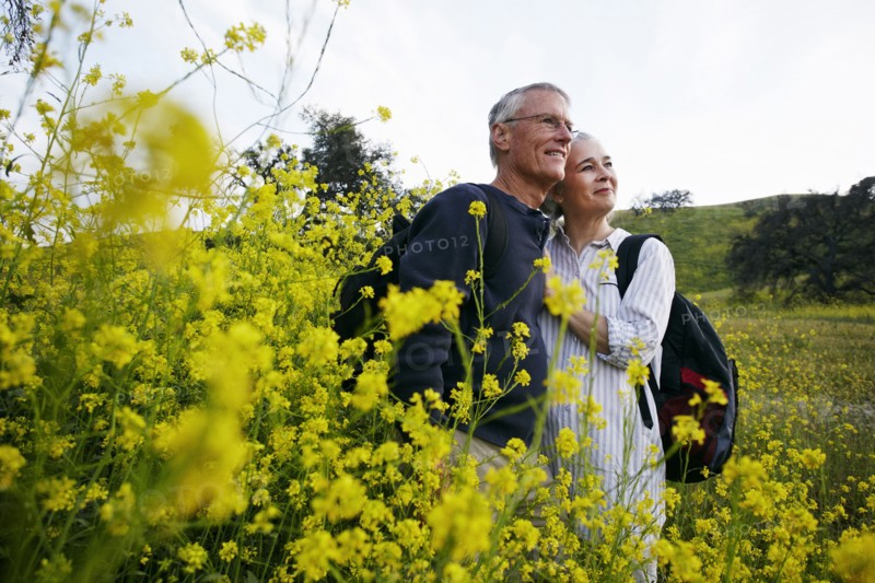 Caucasian couple hugging in tall grass