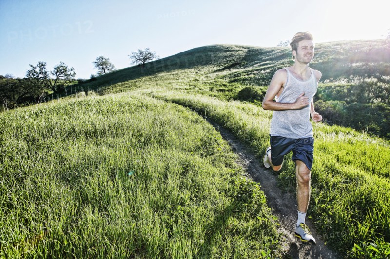 Caucasian athlete running on rural trail
