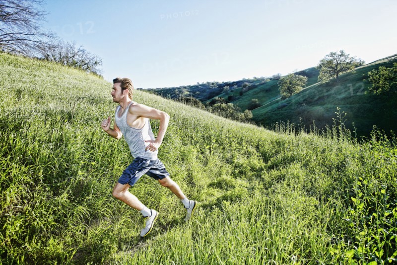 Caucasian athlete running on rural trail