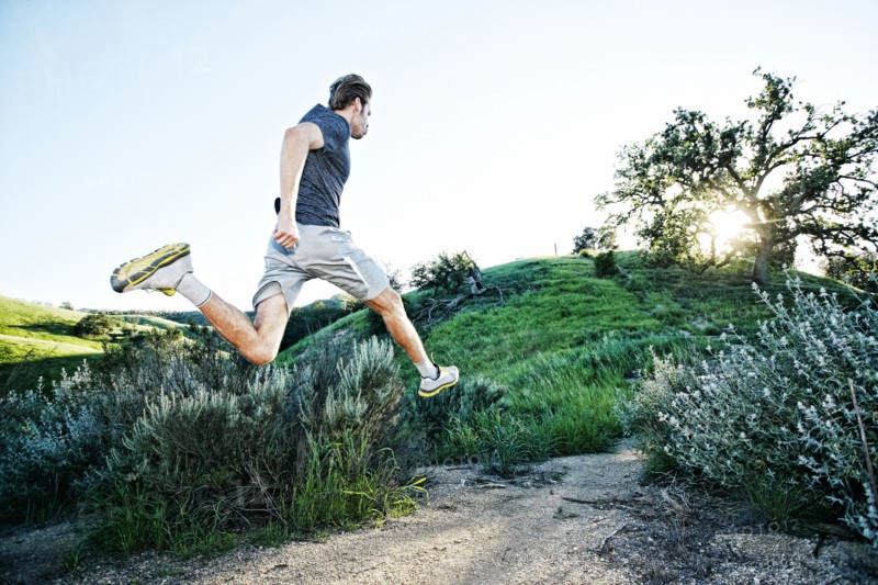 Caucasian athlete running on rural trail