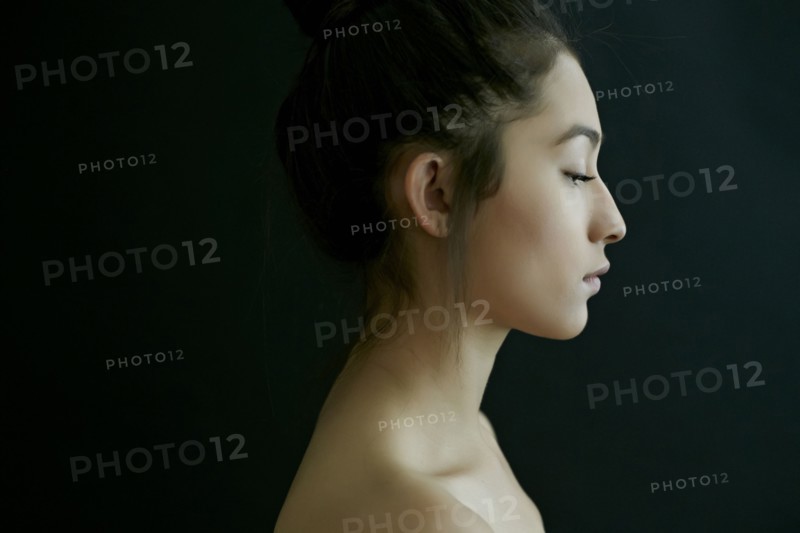 Profile of nude Hispanic woman looking down