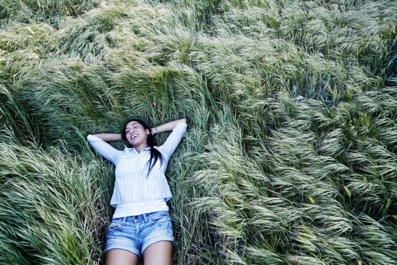 Mixed race woman laying in grass