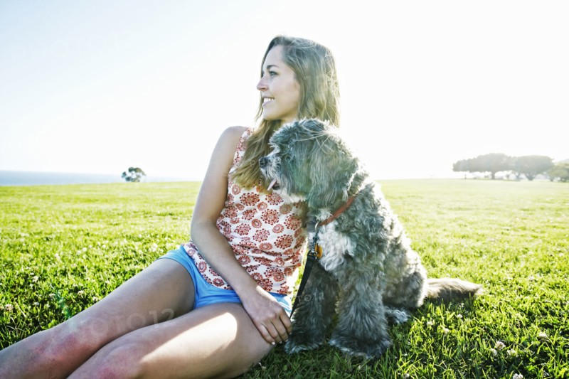 Caucasian woman sitting in field with dog