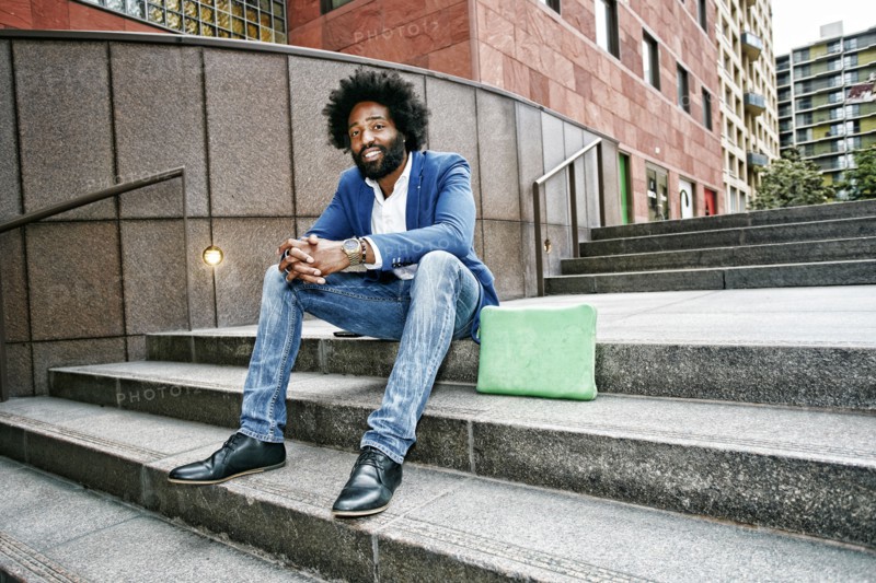 Mixed race businessman sitting on steps