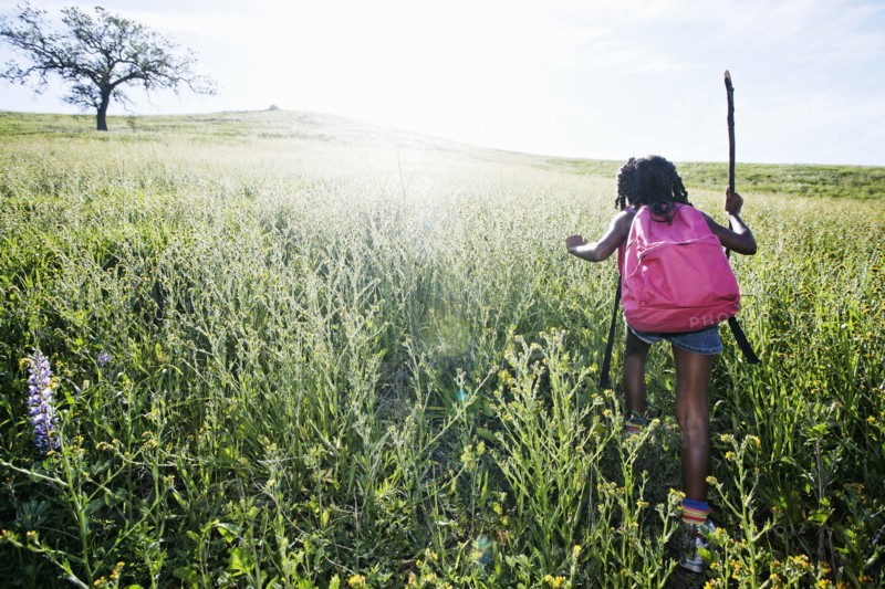 Black girl walking on rural hillside